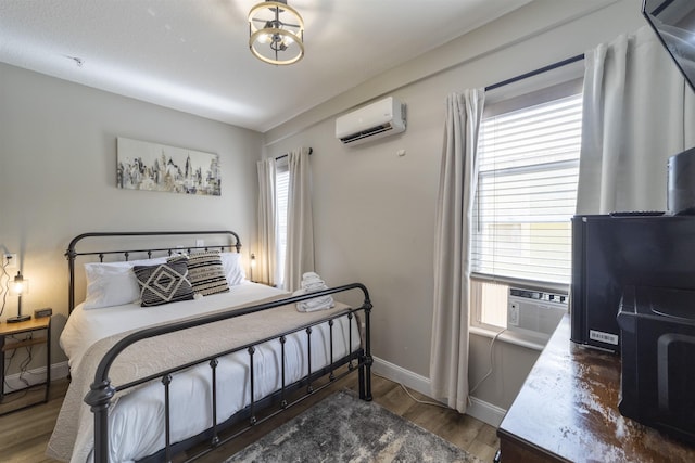 bedroom with a wall mounted air conditioner, dark hardwood / wood-style floors, multiple windows, and cooling unit