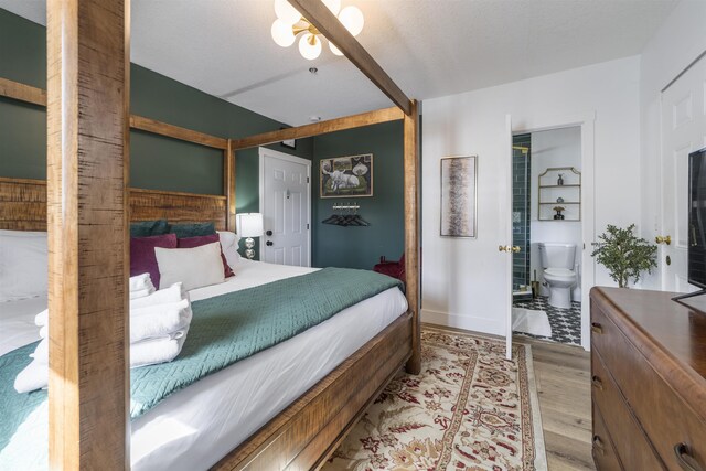 bedroom with connected bathroom, ceiling fan, and light wood-type flooring