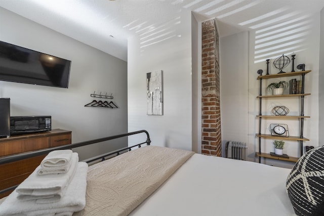 bedroom featuring radiator heating unit and a textured ceiling