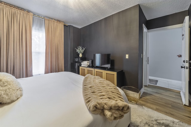 bedroom featuring hardwood / wood-style floors and a textured ceiling