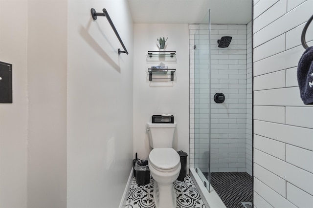 bathroom featuring tile patterned floors, toilet, and a tile shower