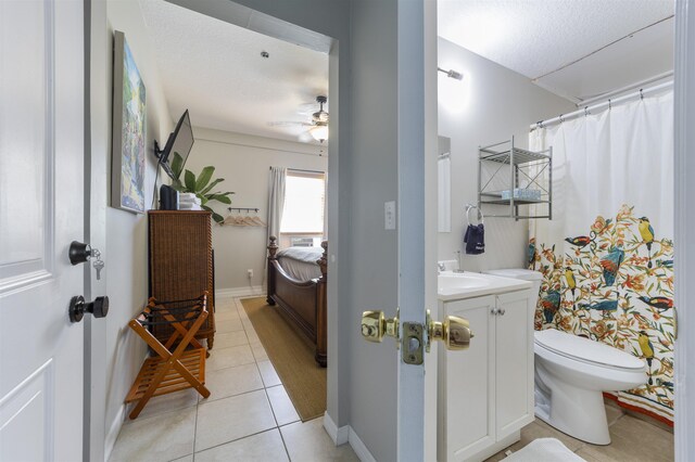 bathroom with tile patterned floors, a textured ceiling, vanity, ceiling fan, and toilet