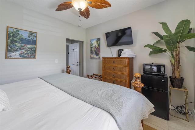 bedroom with black fridge and ceiling fan