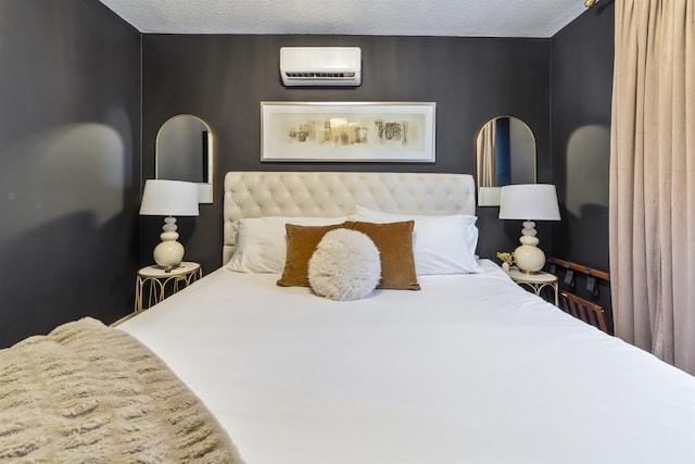 bedroom with a wall unit AC and a textured ceiling