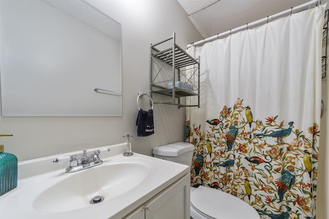 bathroom with vanity, toilet, and a textured ceiling