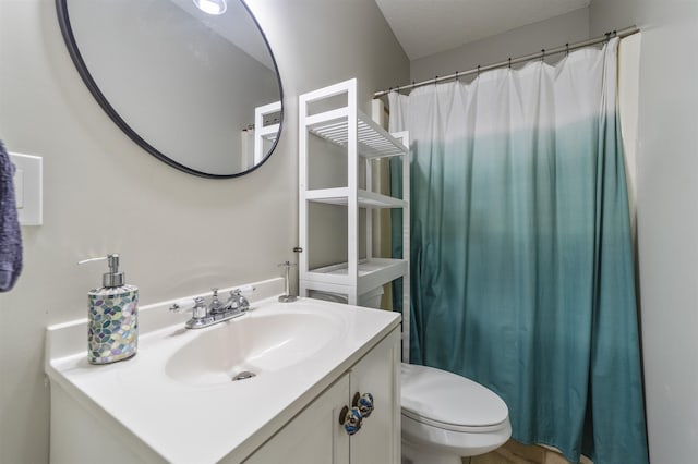 bathroom with vanity, toilet, and a textured ceiling