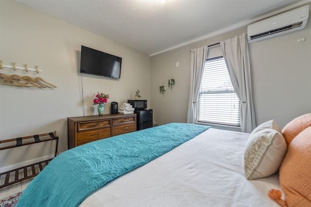 bedroom with an AC wall unit and a textured ceiling