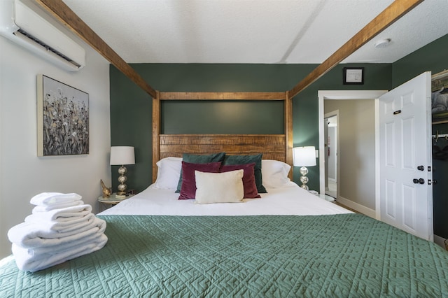 bedroom featuring a wall mounted AC and a textured ceiling