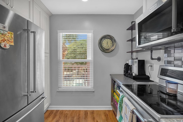 210 16th Street Unit J, Saint Augustine Beach, FL 32080 - kitchen featuring appliances with stainless steel finishes, light wood-style floors, and white cabinets