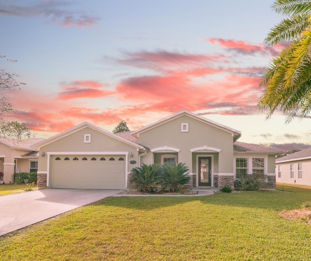 mediterranean / spanish-style house with stone siding, a yard, concrete driveway, and stucco siding