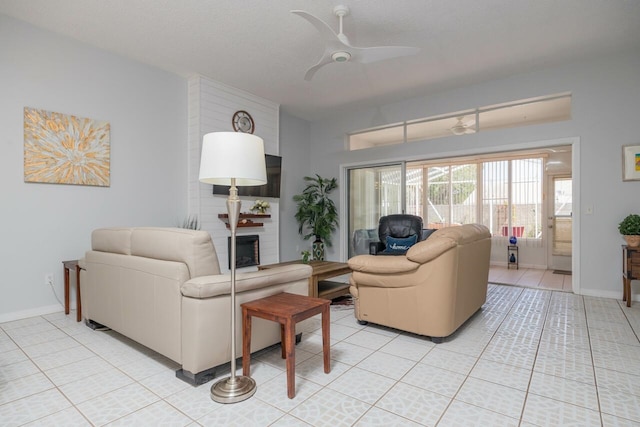 tiled living room with a fireplace and ceiling fan