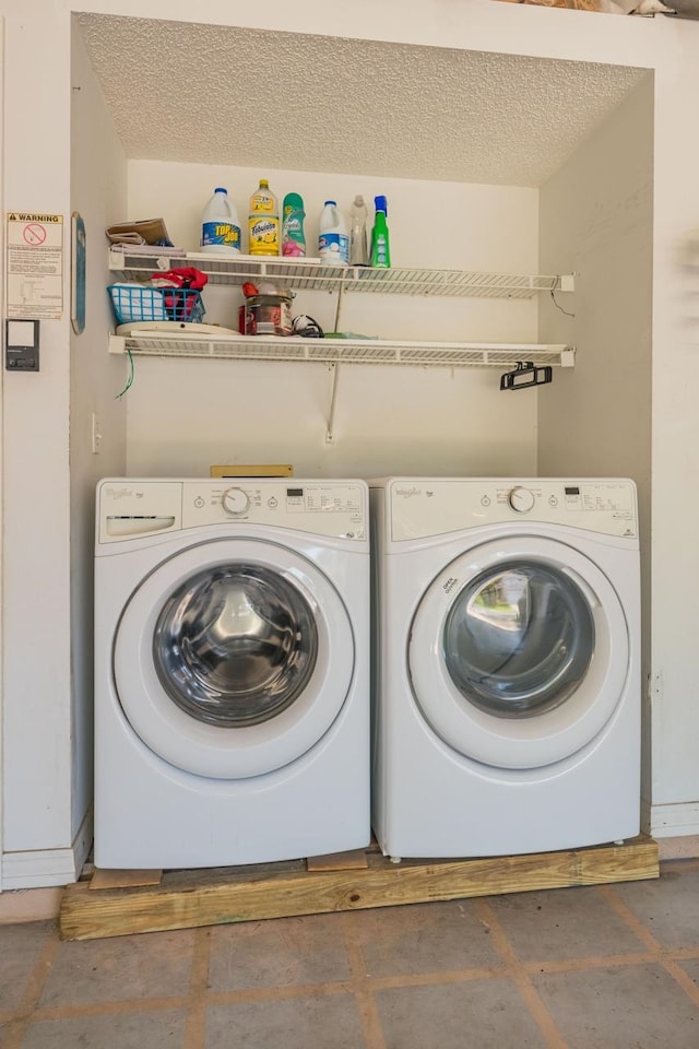 clothes washing area featuring washing machine and clothes dryer and a textured ceiling