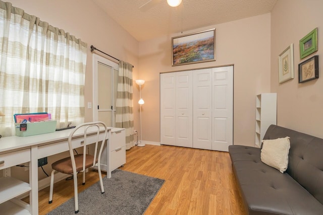 office space with ceiling fan, a textured ceiling, and light wood-type flooring