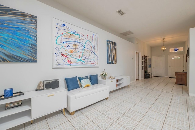 living room with tile patterned flooring and an inviting chandelier