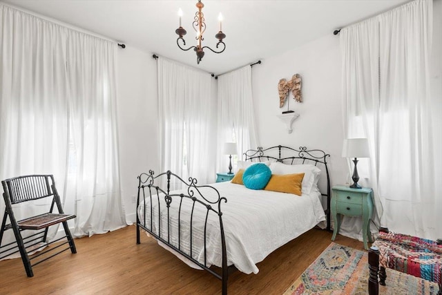 91 Oneida St, Saint Augustine, FL 32084 - bedroom with wood finished floors and an inviting chandelier