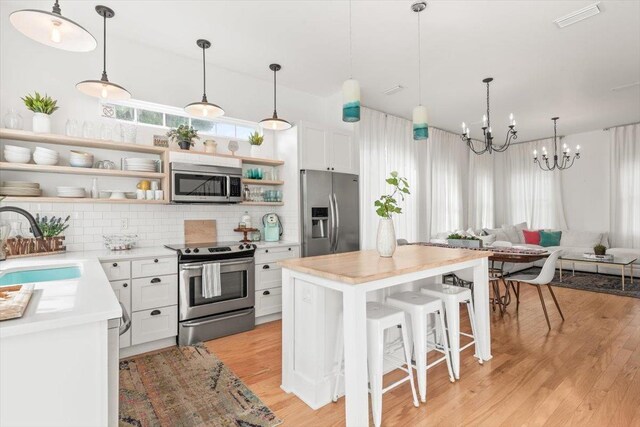 91 Oneida St, Saint Augustine, FL 32084 - kitchen with light countertops, open shelves, visible vents, stainless steel appliances, and a sink