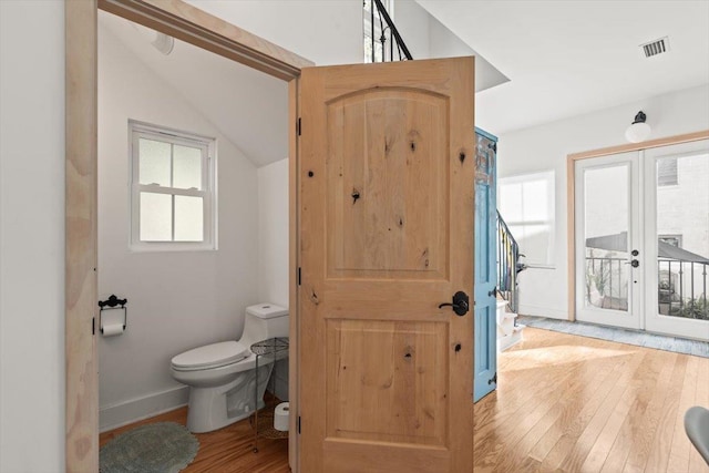 91 Oneida St, Saint Augustine, FL 32084 - bathroom featuring visible vents, baseboards, toilet, wood-type flooring, and french doors