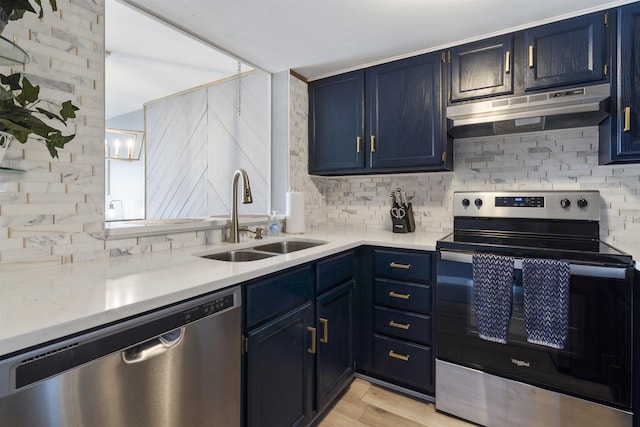 kitchen with backsplash, stainless steel appliances, sink, blue cabinetry, and light hardwood / wood-style floors