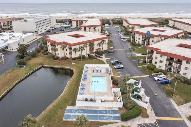 bird's eye view featuring a water view and a beach view