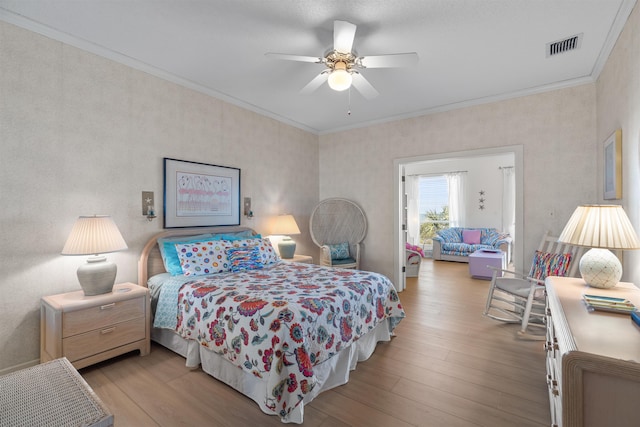 bedroom featuring ornamental molding, ceiling fan, and light hardwood / wood-style floors