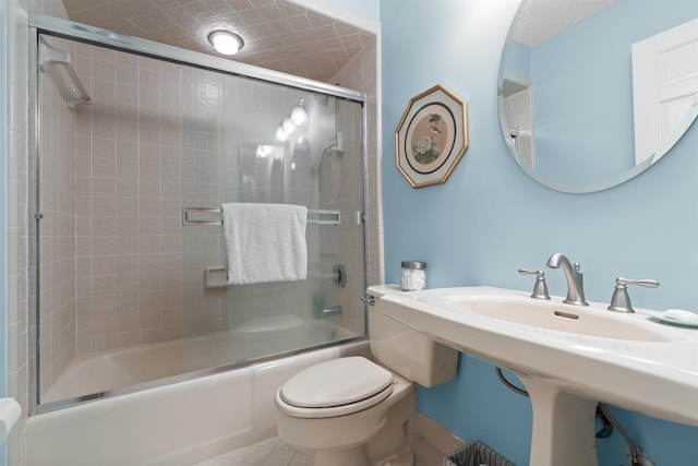 bathroom featuring enclosed tub / shower combo, tile patterned floors, and toilet