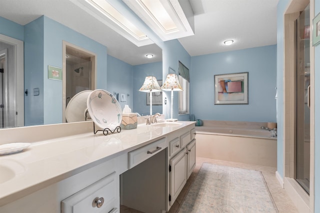 bathroom with vanity, tile patterned flooring, a skylight, and independent shower and bath