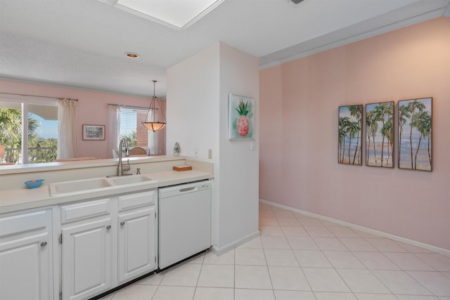 kitchen featuring sink, hanging light fixtures, light tile patterned floors, dishwasher, and white cabinets