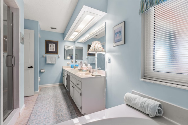 bathroom with a shower with door, vanity, a textured ceiling, tile patterned floors, and toilet