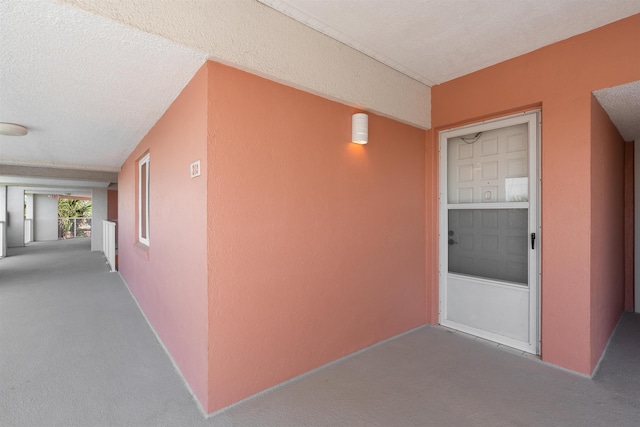 hallway featuring carpet and a textured ceiling