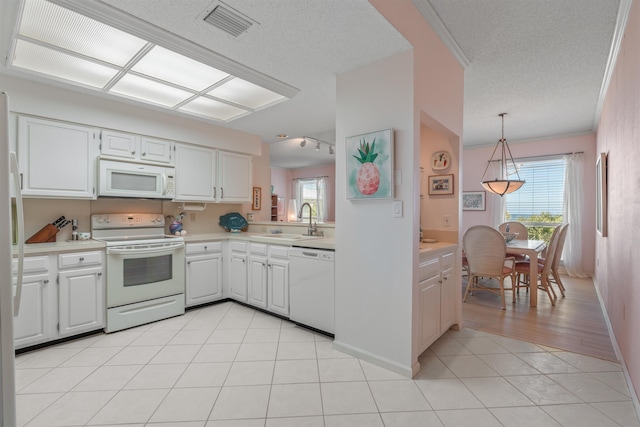 kitchen with pendant lighting, sink, white appliances, light tile patterned floors, and white cabinets