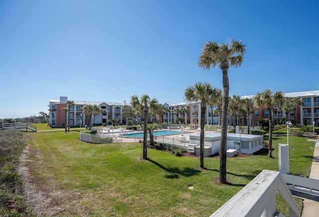 view of property's community with a swimming pool and a yard