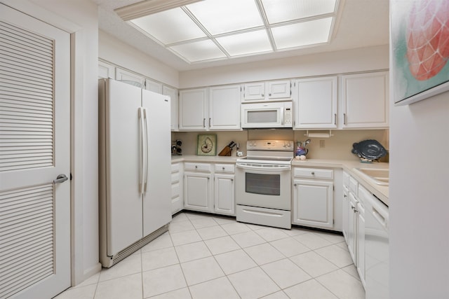 kitchen featuring sink, light tile patterned floors, white cabinets, and white appliances