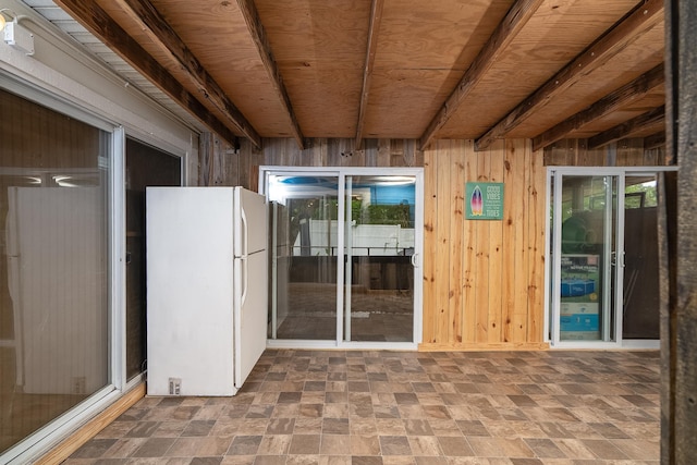 unfurnished sunroom featuring wooden ceiling and beamed ceiling