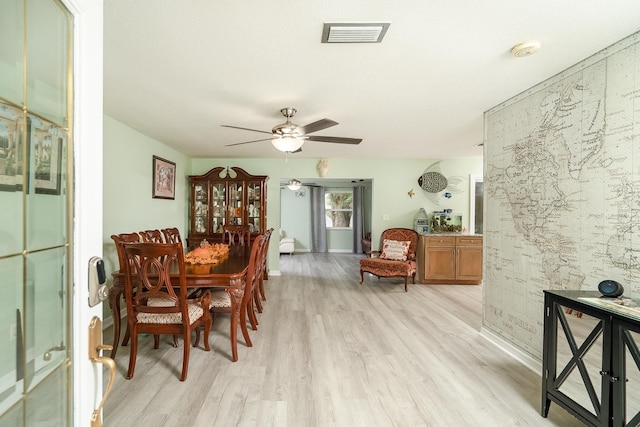 dining space with light hardwood / wood-style floors and ceiling fan