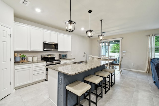 kitchen with white cabinetry, sink, an island with sink, and appliances with stainless steel finishes