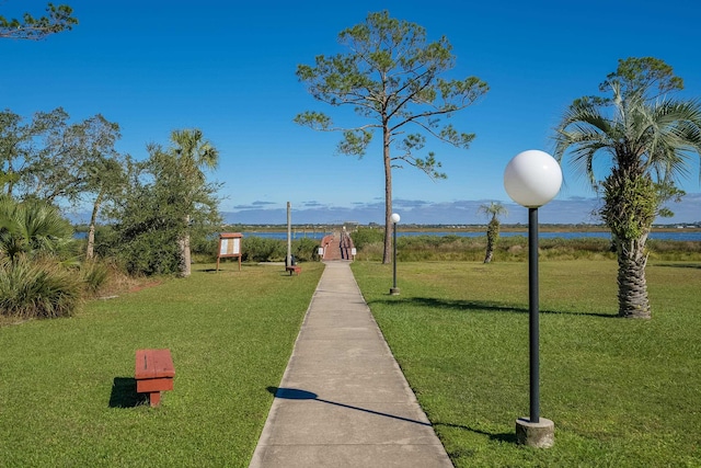 surrounding community with a yard and a water view