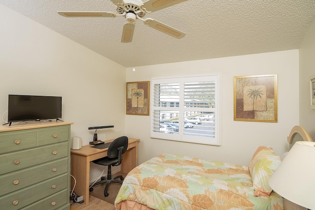 bedroom featuring ceiling fan, lofted ceiling, and a textured ceiling