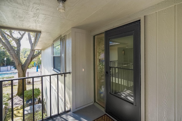 view of exterior entry with a balcony