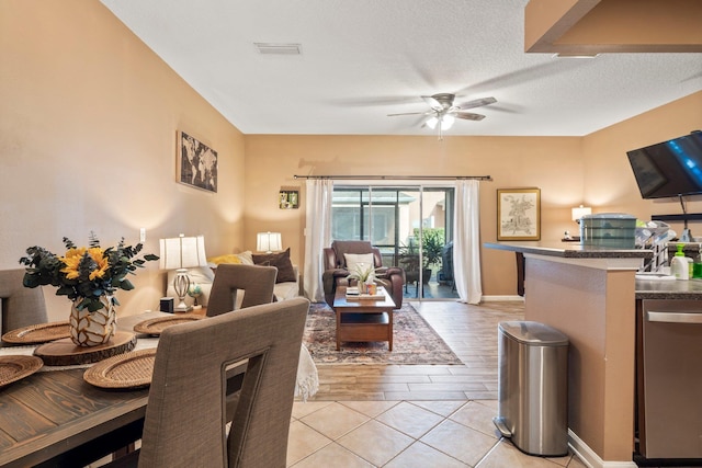 dining room featuring light tile patterned floors, a textured ceiling, and ceiling fan