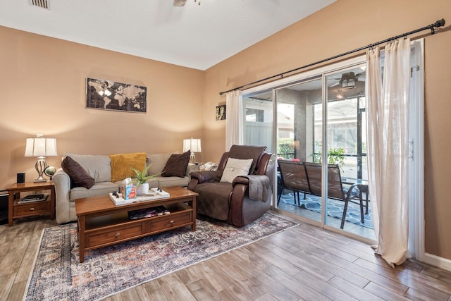 living room featuring hardwood / wood-style floors and ceiling fan