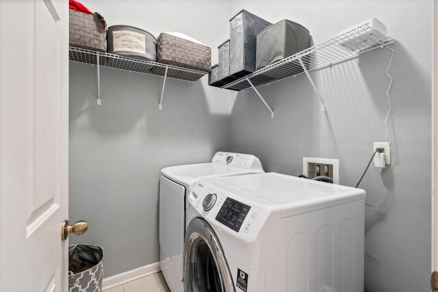 laundry area featuring light tile patterned floors and independent washer and dryer