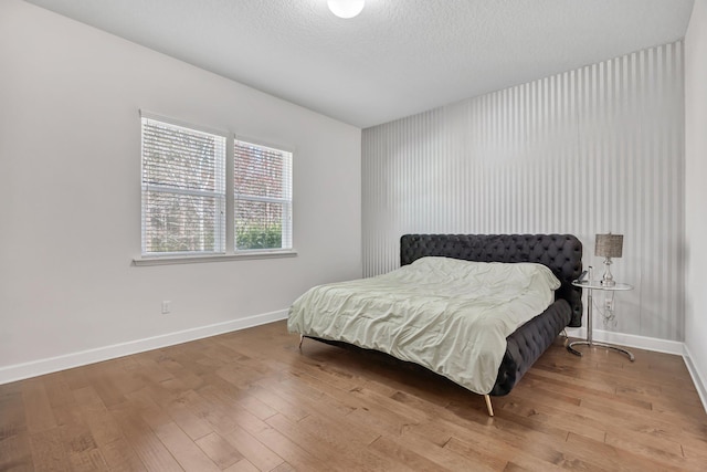 bedroom with hardwood / wood-style floors and a textured ceiling