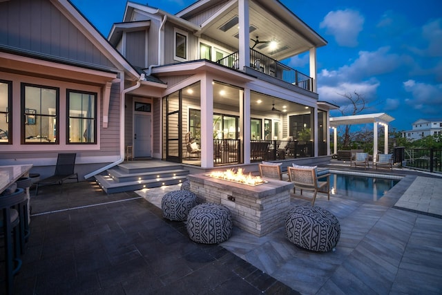 214 Pelican Reef Dr, Saint Augustine, FL 32080 - rear view of property featuring a fire pit, a fenced in pool, a ceiling fan, a patio, and a balcony