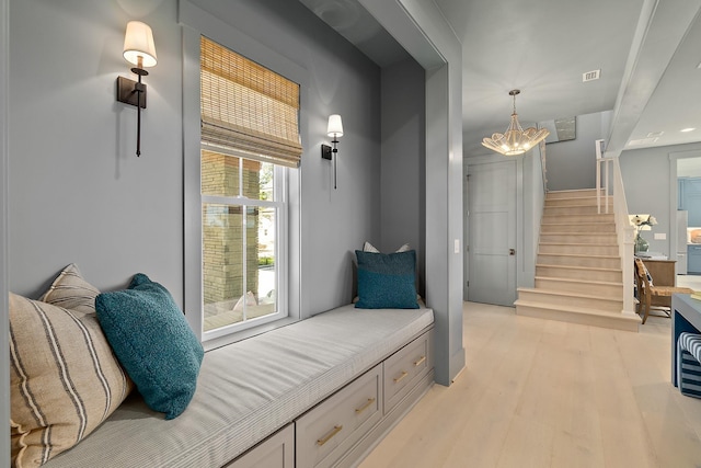 214 Pelican Reef Dr, Saint Augustine, FL 32080 - living area with light wood finished floors, a notable chandelier, and stairway