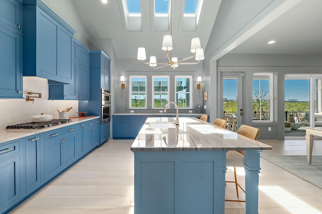 214 Pelican Reef Dr, Saint Augustine, FL 32080 - kitchen with blue cabinets, light stone countertops, a breakfast bar area, stainless steel appliances, and a sink