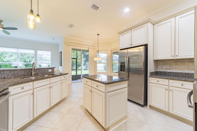 kitchen with appliances with stainless steel finishes, ceiling fan, sink, pendant lighting, and cream cabinetry