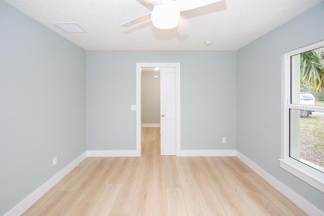 spare room with a textured ceiling, light wood-type flooring, and ceiling fan