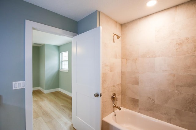 bathroom with wood-type flooring and tiled shower / bath