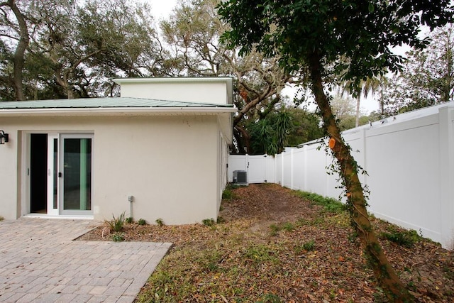 view of side of property with central AC unit and a patio area