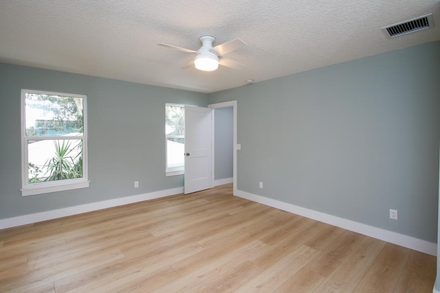 spare room featuring ceiling fan, a textured ceiling, and light wood-type flooring